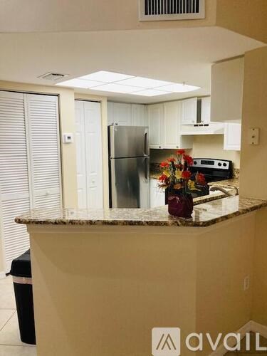 A kitchen with a granite countertop and a refrigerator.