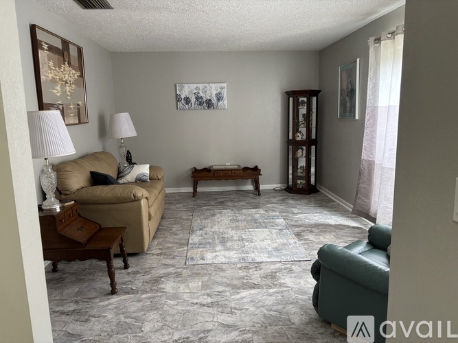 A living room with a couch, a coffee table, and a lamp.