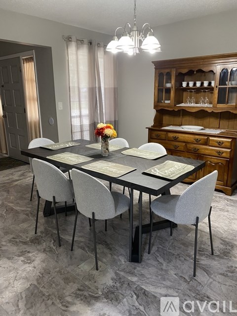A dining room with a table set for four.
