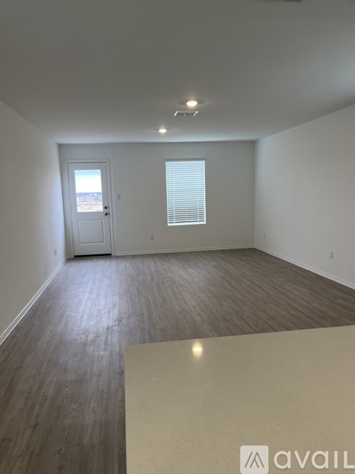 A room with a white door and a window with blinds.