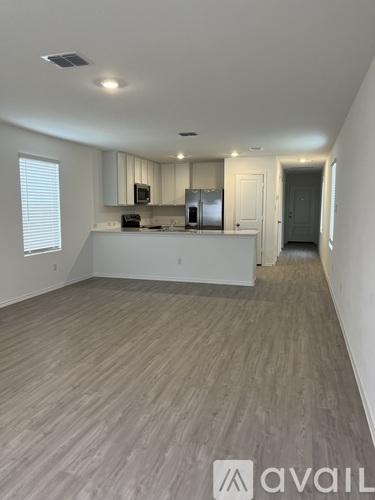 A spacious kitchen with white cabinets and a countertop.
