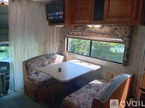 A small bedroom with a bed and a television mounted above it.