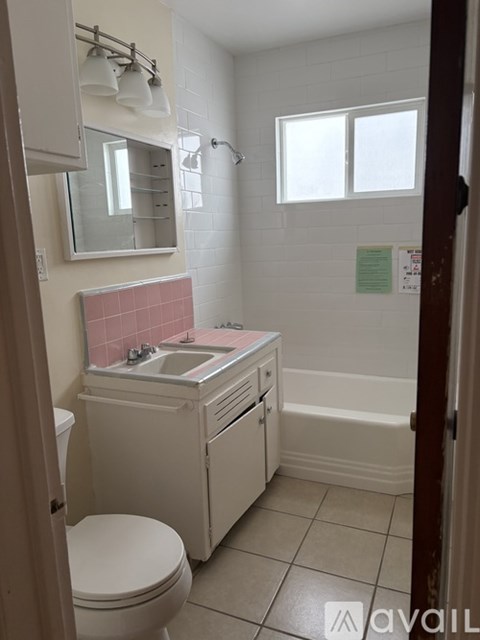 A bathroom with a toilet, sink, and mirror.