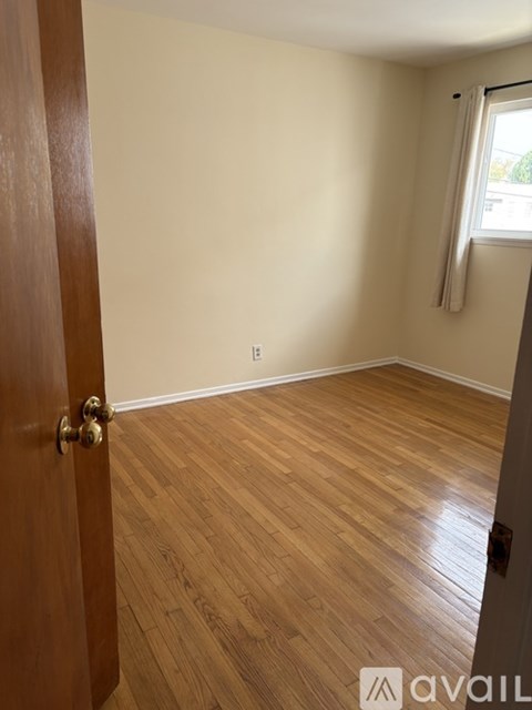 A room with wooden flooring and a closed door.
