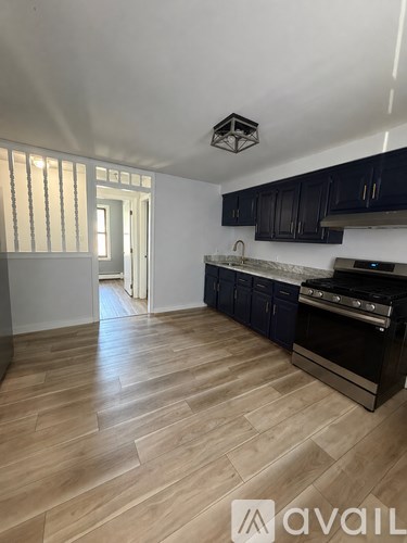 A kitchen with dark cabinets and a wooden floor.