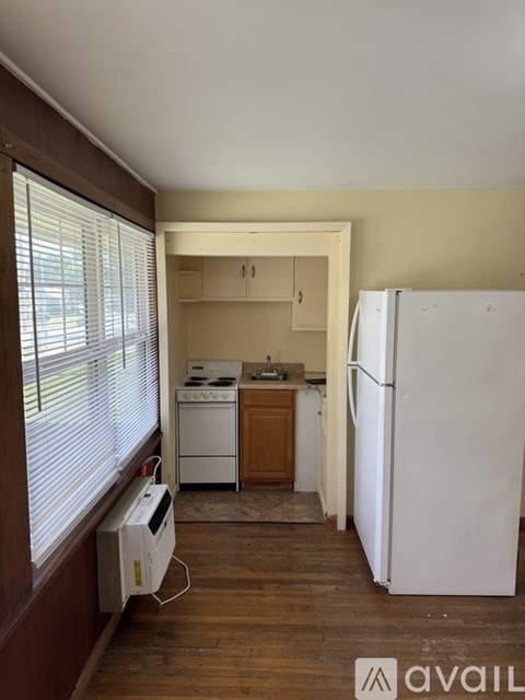 A kitchen with a white fridge and a washing machine.