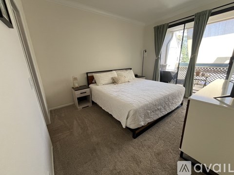 A bedroom with a large bed and a nightstand.