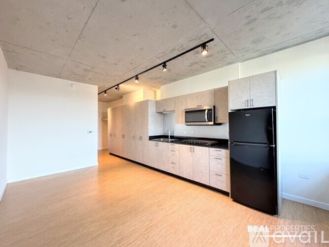 A spacious kitchen with black appliances and wooden cabinets.