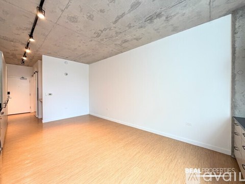 A room with a wooden floor and a concrete ceiling.