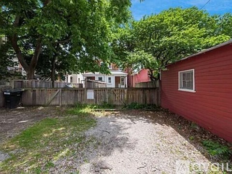 A red building with a gravel area in front of it.