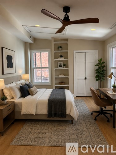 A bedroom with a bed, a desk, and a ceiling fan.