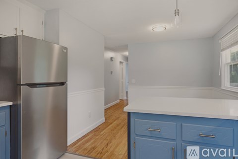 A kitchen with a stainless steel refrigerator and blue cabinets.