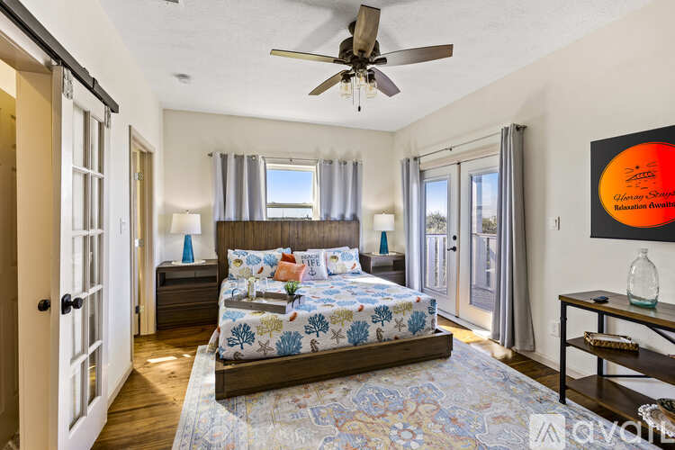 A bedroom with a large bed and a ceiling fan.