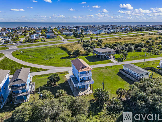 A bird's eye view of a residential area with houses and a large open grassy area.