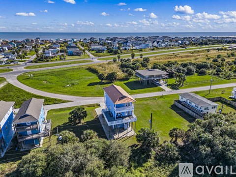 A bird's eye view of a residential area with houses and a large open grassy area.
