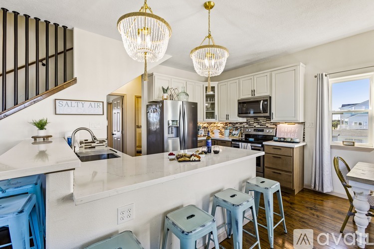 A kitchen with a white counter top and blue stools.