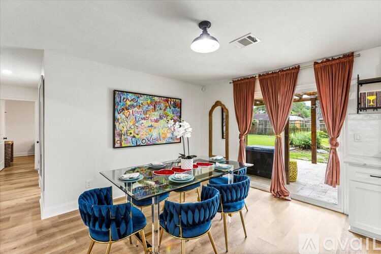 A dining room with a glass table and blue chairs.