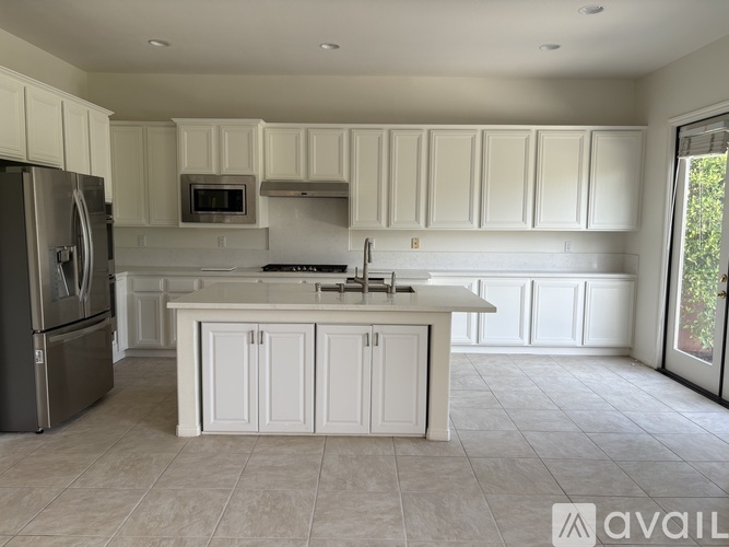 A kitchen with white cabinets and a large island.
