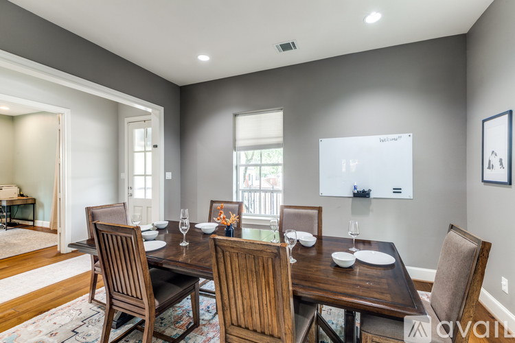 A dining room with a wooden table and chairs.