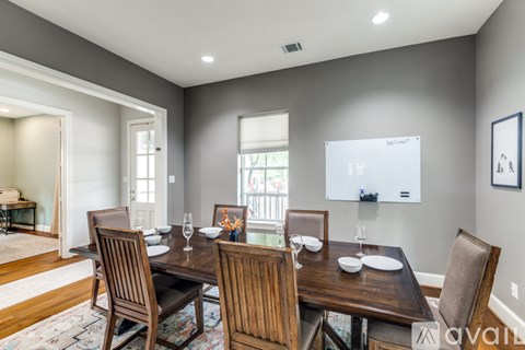 A dining room with a wooden table and chairs.