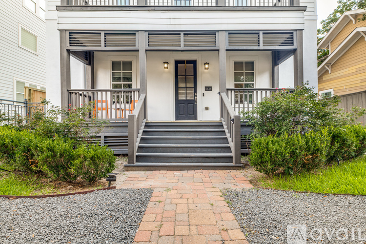 A white house with a black door and steps leading to the entrance.
