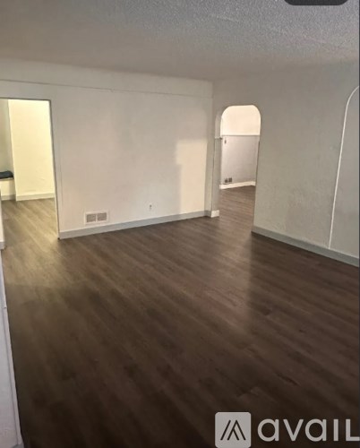 A room with wooden flooring and white walls.
