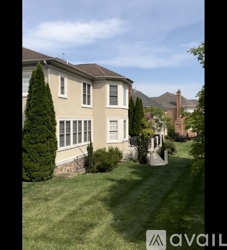A house with a well-manicured lawn and a clear sky.
