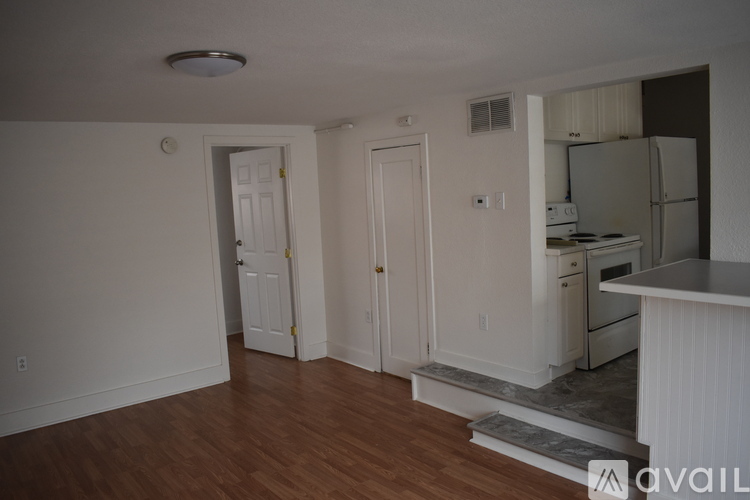 A kitchen with white cabinets and a refrigerator.