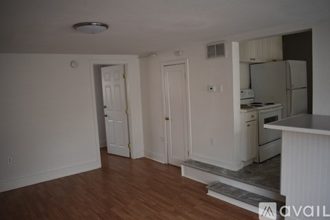 A kitchen with white cabinets and a refrigerator.