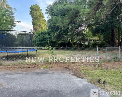 A playground with a blue trampoline and a sign that says "NDW PROPERTIES".