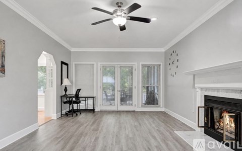A spacious room with a fireplace and a ceiling fan.