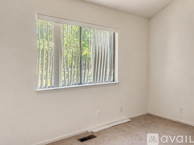 A room with a window that has a view of trees outside.