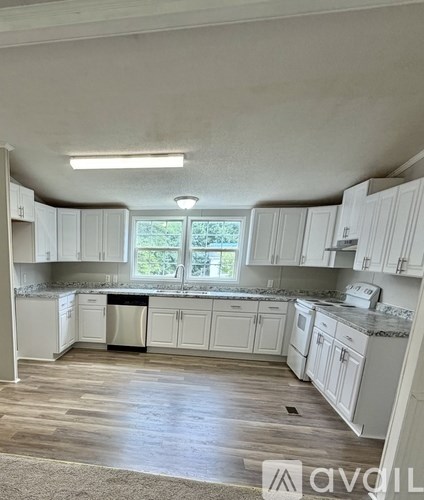 A kitchen with white cabinets and a window.