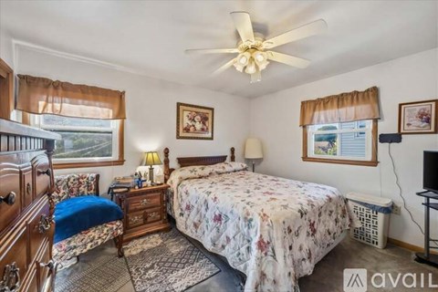 A bedroom with a large bed and a ceiling fan.