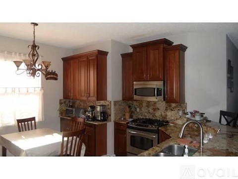 A kitchen with granite countertops and wooden cabinets.