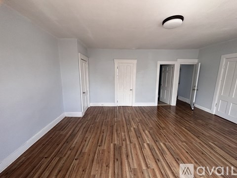 A room with wooden flooring and white walls.