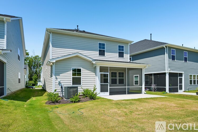 A house with a grey exterior and a green lawn in front.
