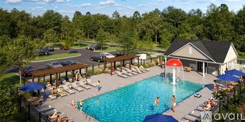 A large pool with a waterfall and people relaxing in the sun.