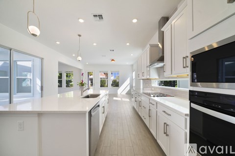 A modern kitchen with white cabinets and appliances.