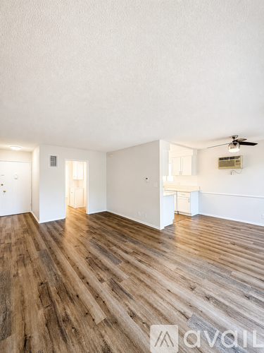 A room with wooden flooring and white walls.