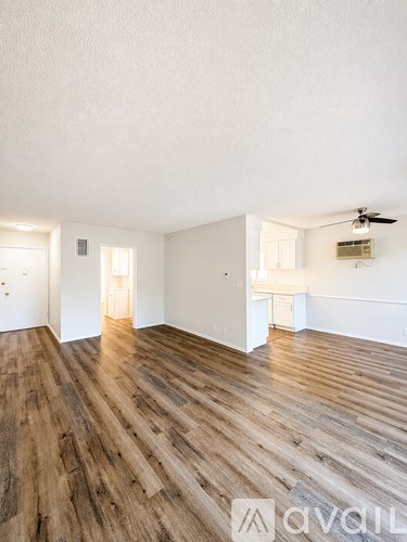 A room with wooden flooring and white walls.