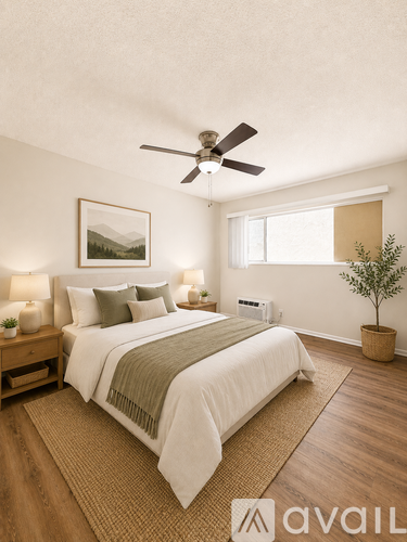 A bedroom with a large bed, a ceiling fan, and a small tree in a pot.