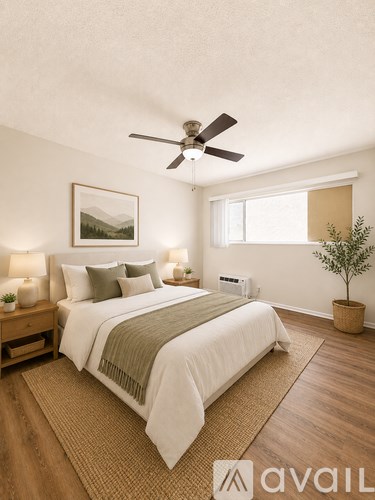 A bedroom with a large bed, a ceiling fan, and a small tree in a pot.