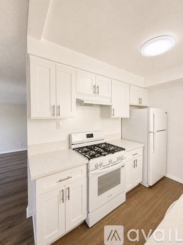 A kitchen with white cabinets and a stove top oven.