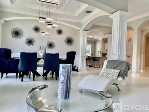A modern dining room with a glass table and blue chairs.