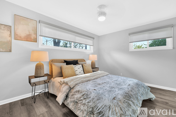 A bedroom with a bed, two lamps, and two framed pictures on the wall.