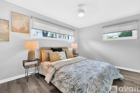 A bedroom with a bed, two lamps, and two framed pictures on the wall.