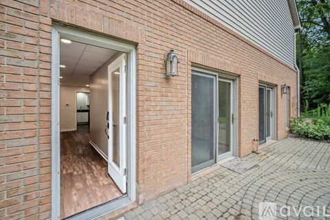 A brick house with a white door and windows.