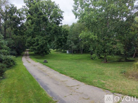 A pathway in a park with trees on both sides.
