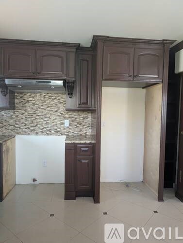 A kitchen with brown cabinets and a tiled backsplash.